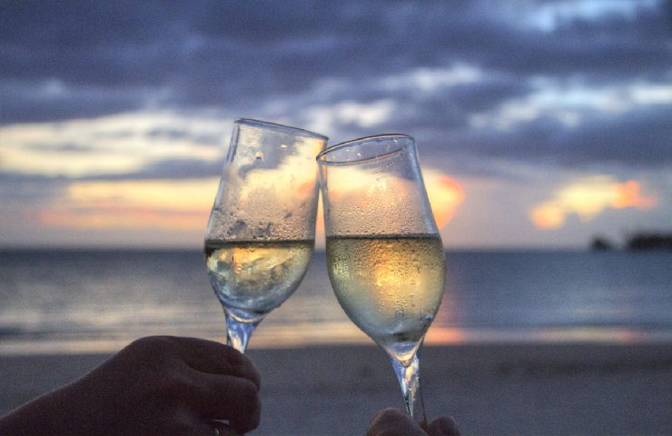 Brindisi con vino bianco in riva al mare