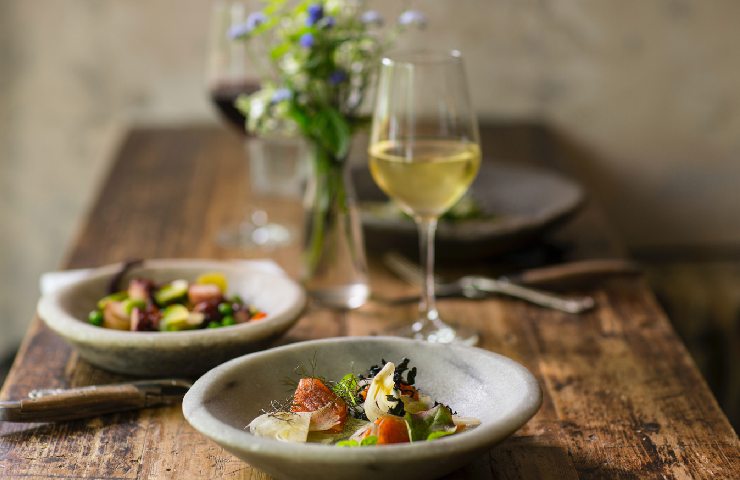 calici di vino bianco in abbinamento a insalate con salmone