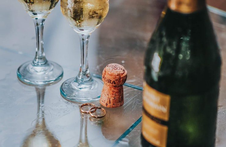 Due bicchieri di prosecco, una bottiglia e un tappo