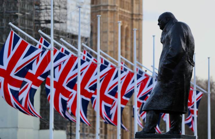 Statua di Churchill in Inghilterra, con davanti diverse bandiere del Regno Unito