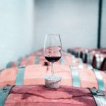Vino rosso in un calice sopra a delle botti