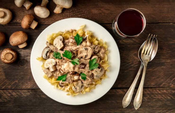 Pasta con i funghi e bicchiere di vino rosso