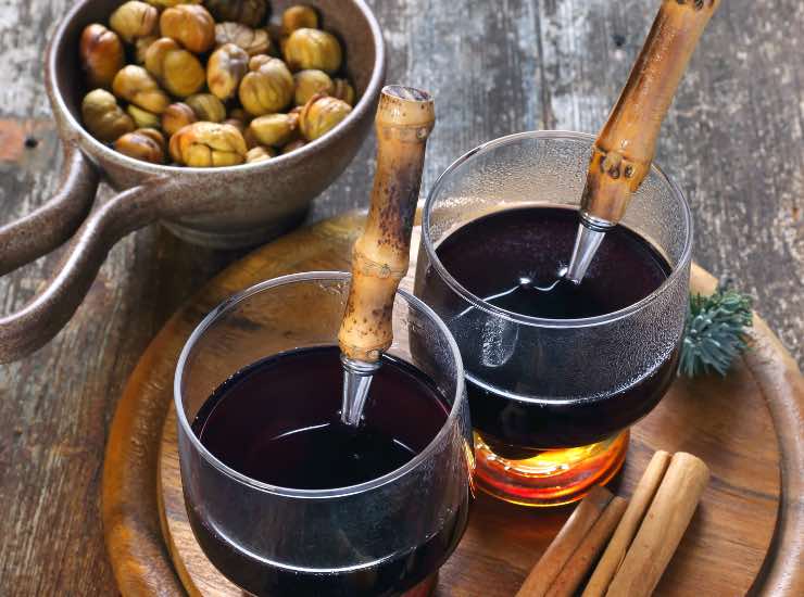 Vino rosso e castagne su un vassoio di legno