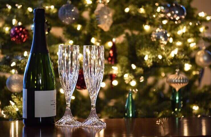 bottiglia di vino e calici con albero di Natale