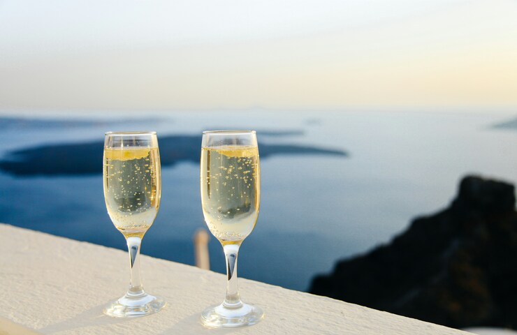 calici di vino bianco su davanzale vista mare