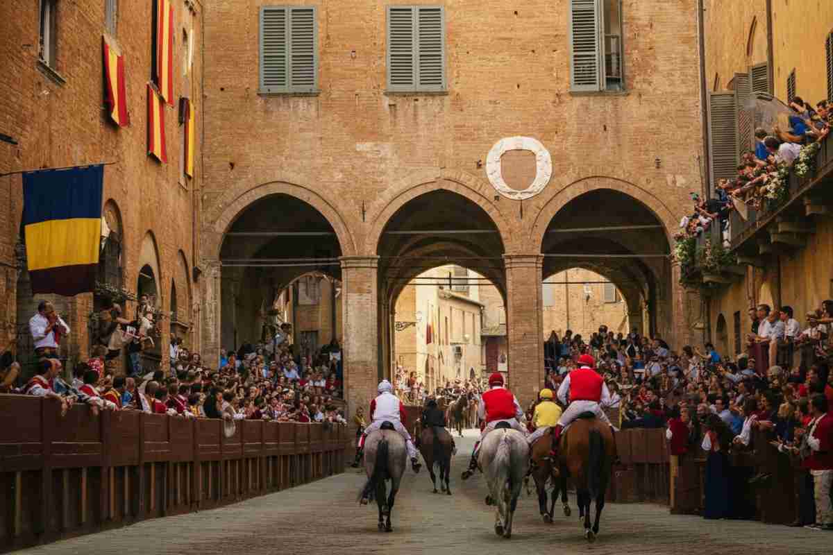 Il drappellone del Palio di Siena si tinge di vino: una tradizione che sorprende